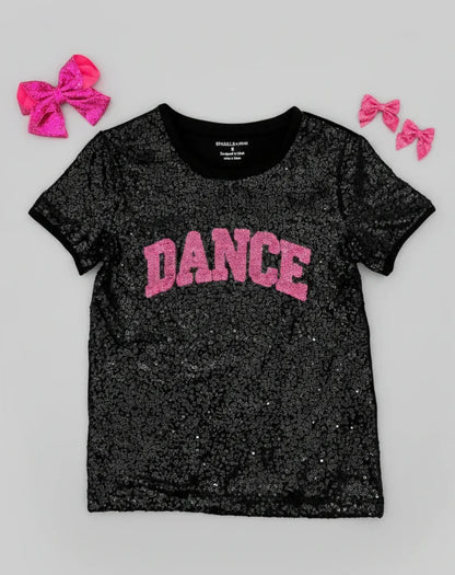 Black glittery t-shirt with 'DANCE' in pink on a gray background